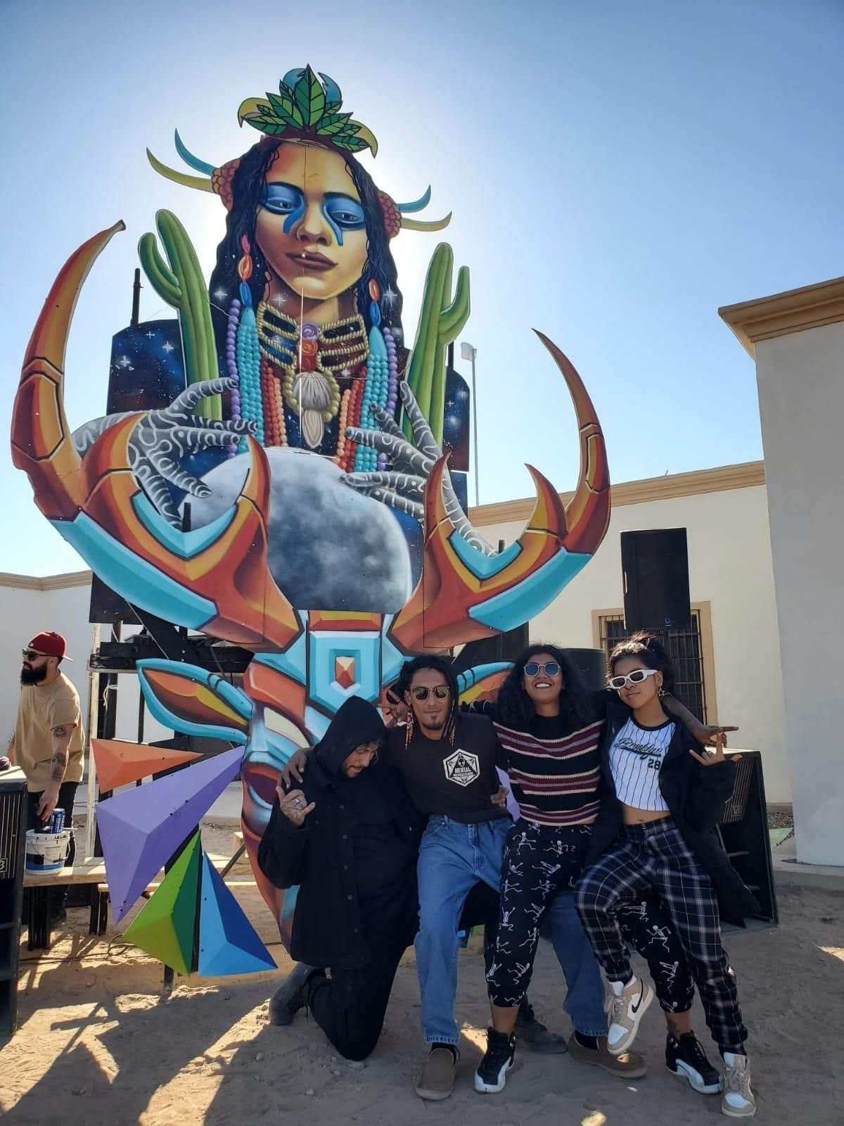 Via junto a su equipo frente a una escultura colectiva