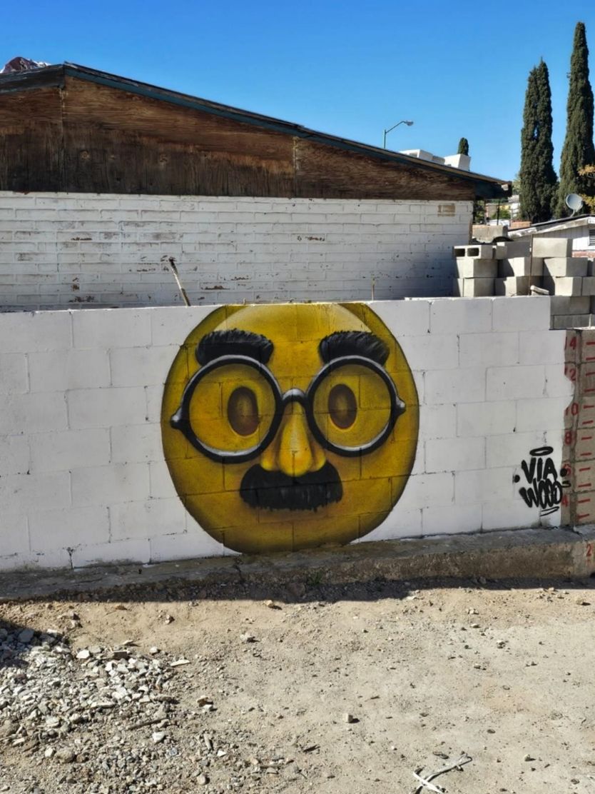 Mural ilustrado de personaje con lentes, firma VIA WOOD