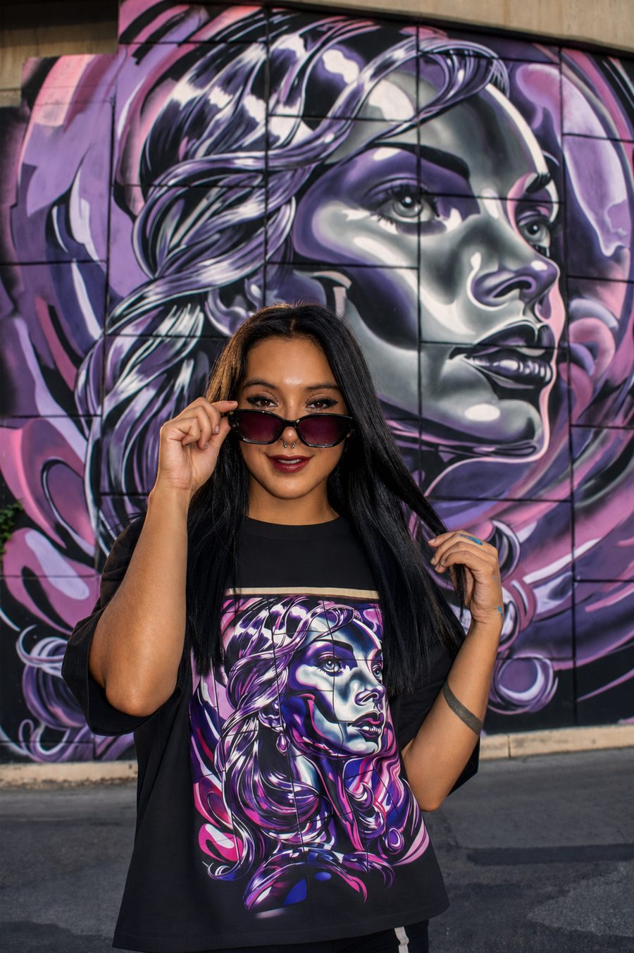 Via frente a uno de sus murales de rostro en tonos morados